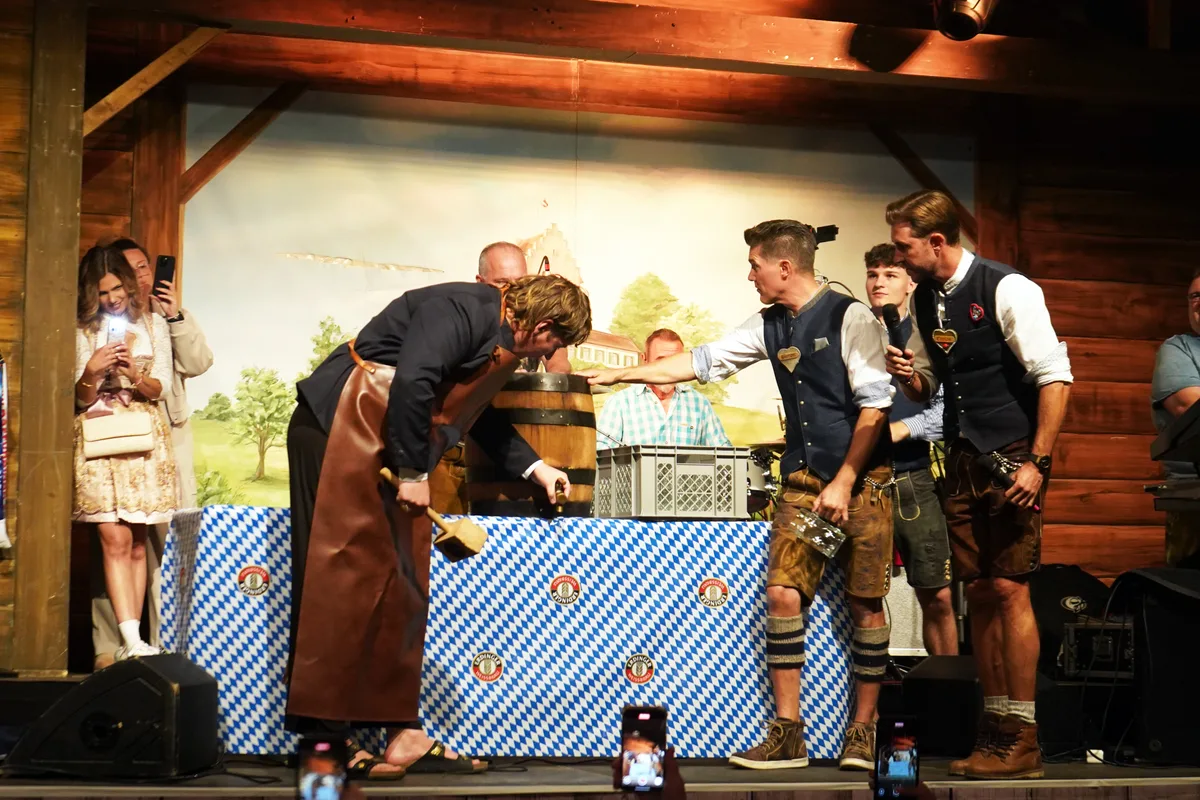 Mit kräftigen Schlägen sticht Marius Bear das erste Fass an … Man sieht Impressionen des Oktoberfestes 2025 in Uster